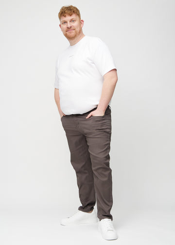 Helbild av en plus size-modell i gråbruna regular jeans.