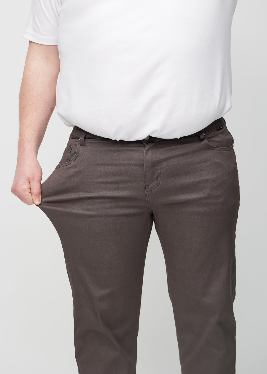 Plus size-modellen sträcker jeansen vid låret för att visa stretch.