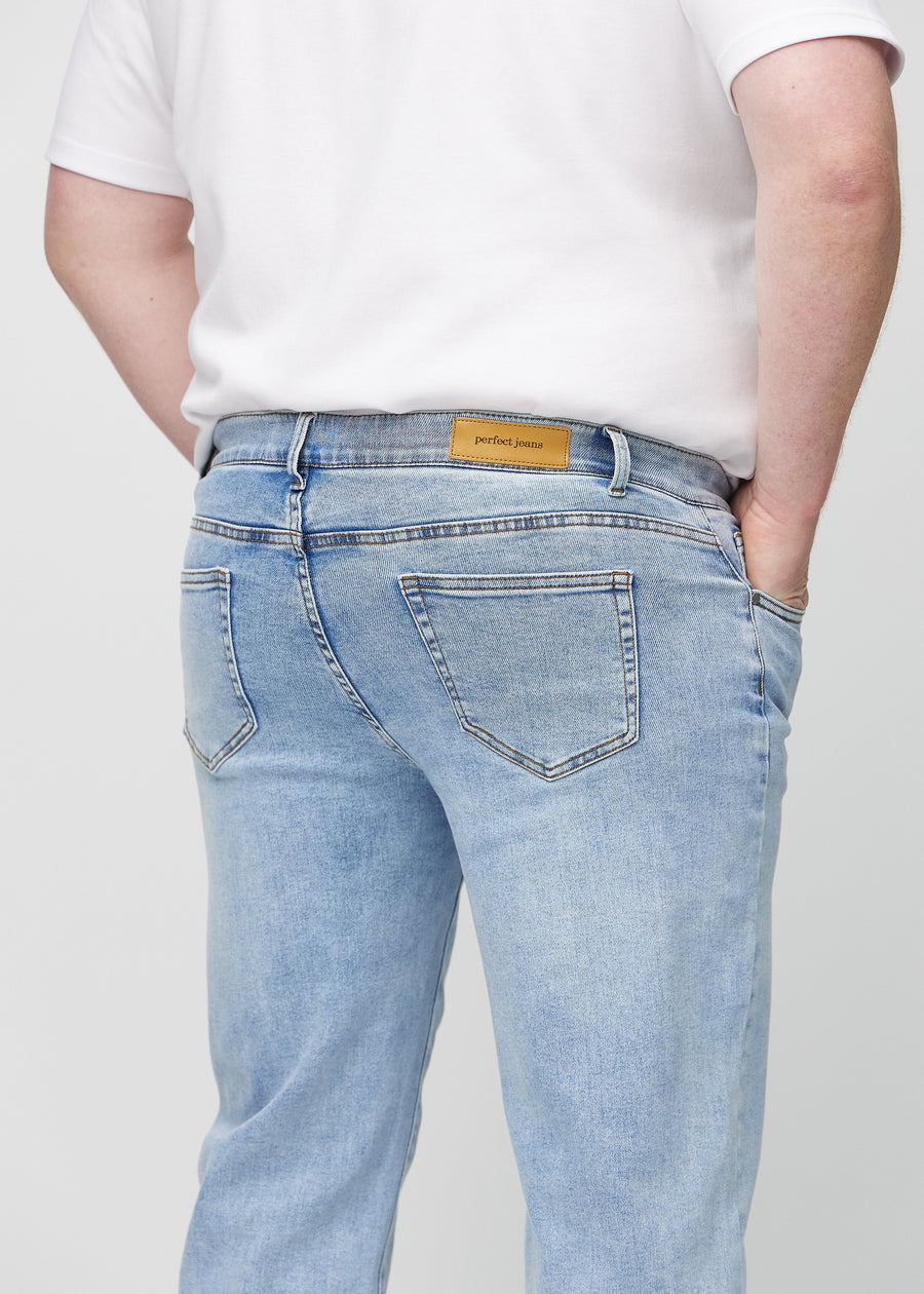 Ljus denim regular jeans sett bakifrån i närbild på en plus size-modell för att visa detaljer.