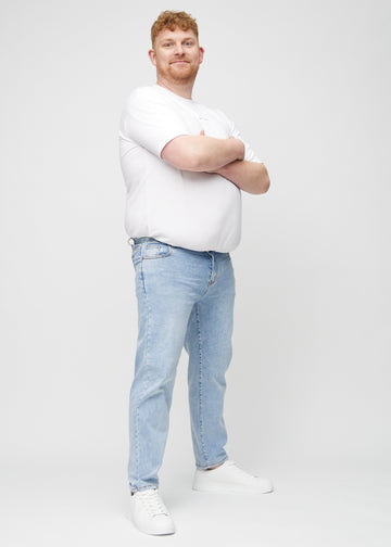 Helbild av en plus size-modell i ljus denim regular jeans.