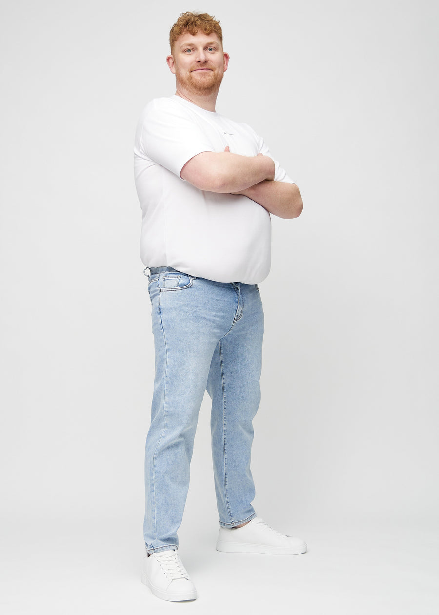Helbild av en plus size-modell i ljus denim regular jeans.