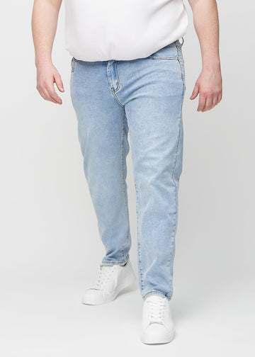 Ljus denim regular jeans, modellnamn Waves, som går rakt ner längs benet på en plus size-modell, sett framifrån.