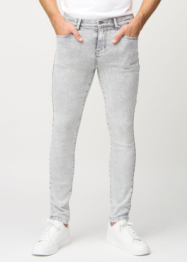 Ljusgrå denimjeans i slim fit, modellnamn Ashes, som sitter tätt längs benen , sedda framifrån.