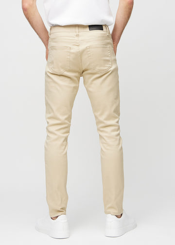 Beige jeans i slim fit sedda bakifrån för att visa hela produkten.