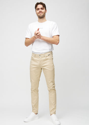 Helbild av en modell i beige jeans i slim fit.