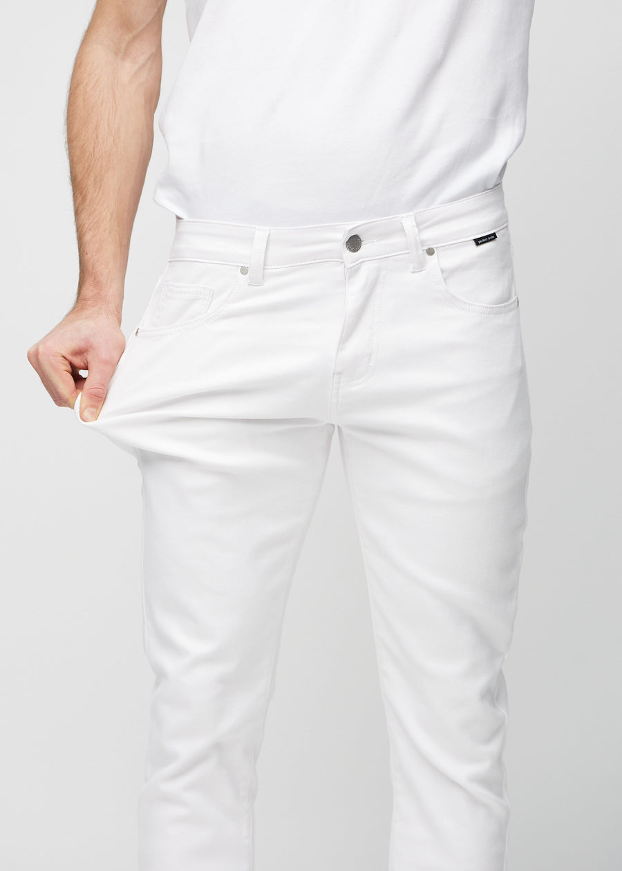 Model strækker jeansene ved låret for at vise stretch.
