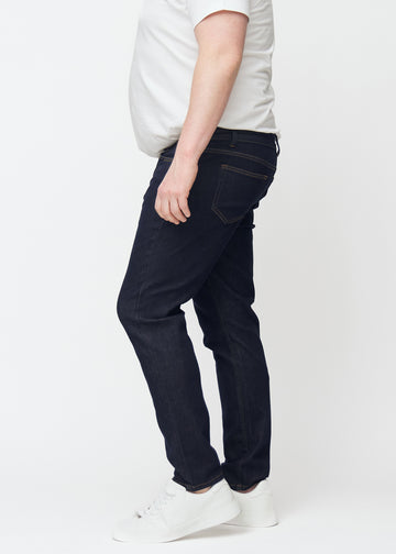 Djupt mörkblå denim jeans för män i färgen Midnights med slim passform sedd från sidan på plus-size-modell.