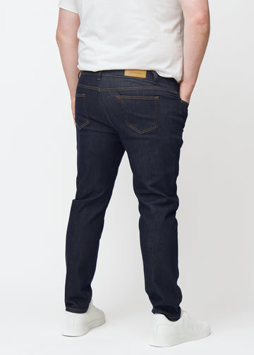 Djupt mörkblå denim jeans för män i färgen Midnights sedd bakifrån på plus-size-modell.