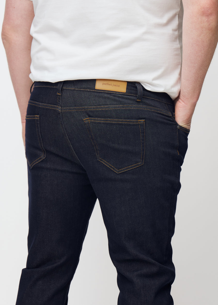 Djupt mörkblå denim jeans för män i färgen Midnights sedd bakifrån i närbild på plus-size-modell.