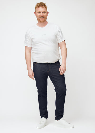 Helbild av plus-size-modell i djupt mörkblå denim jeans för män i färgen Midnights med slim passform.