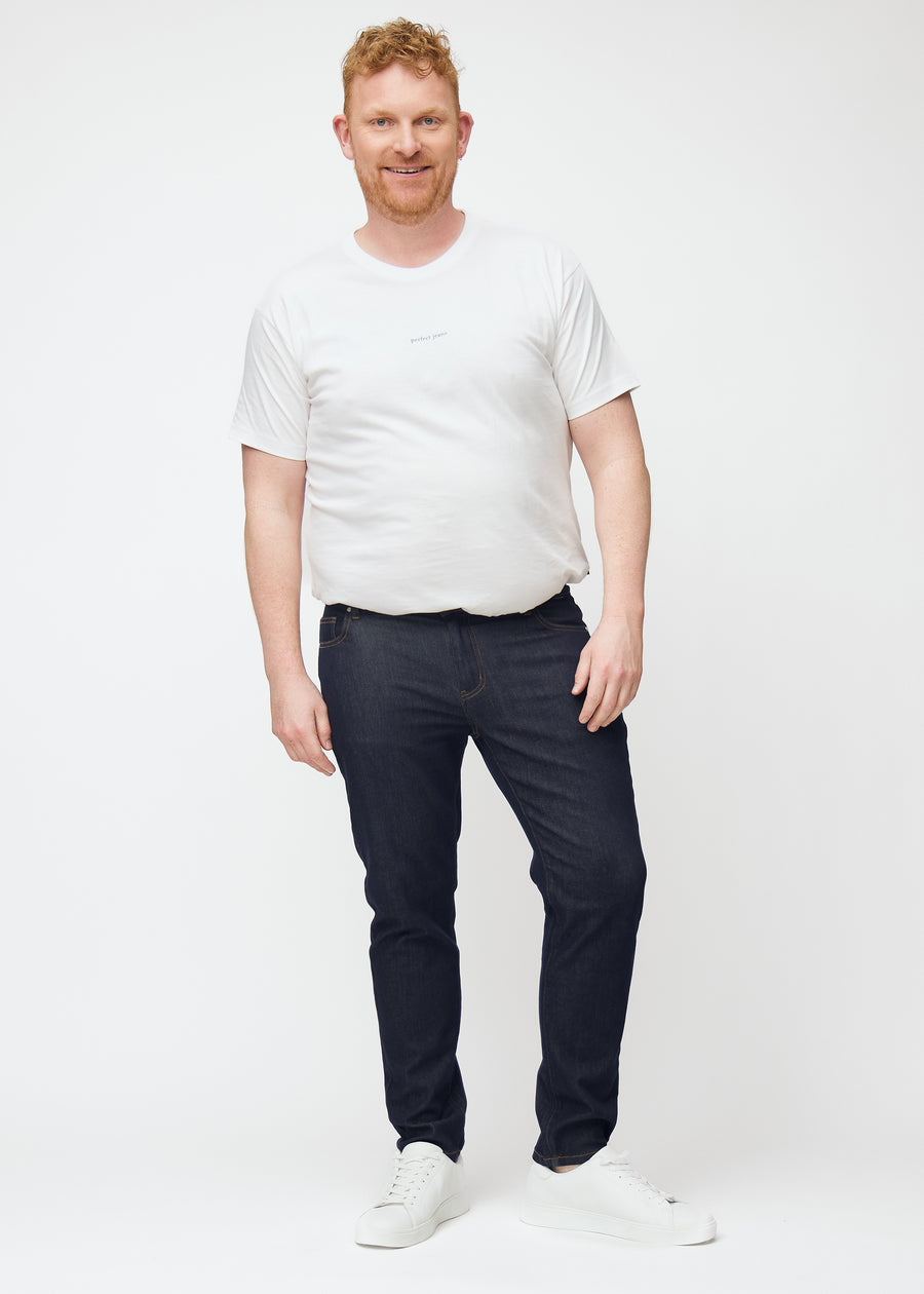 Helbild av plus-size-modell i djupt mörkblå denim jeans för män i färgen Midnights med slim passform.