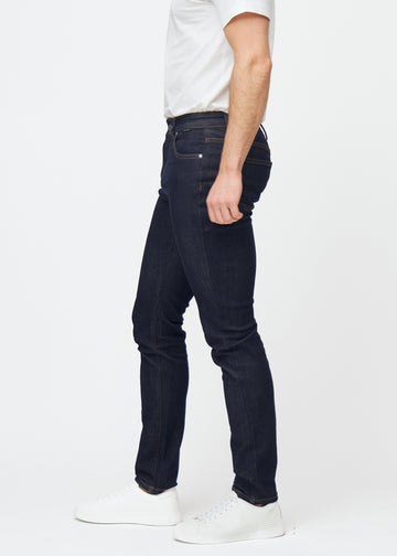Djupt mörkblå denim jeans för män i färgen Midnights med slim passform sedd från sidan på modell.