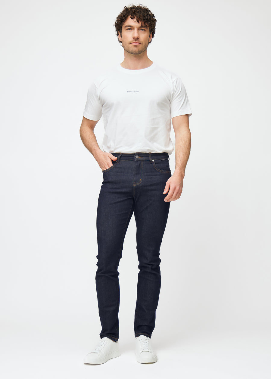 Helbild av modell i djupt mörkblå denim jeans för män i färgen Midnights med slim passform.