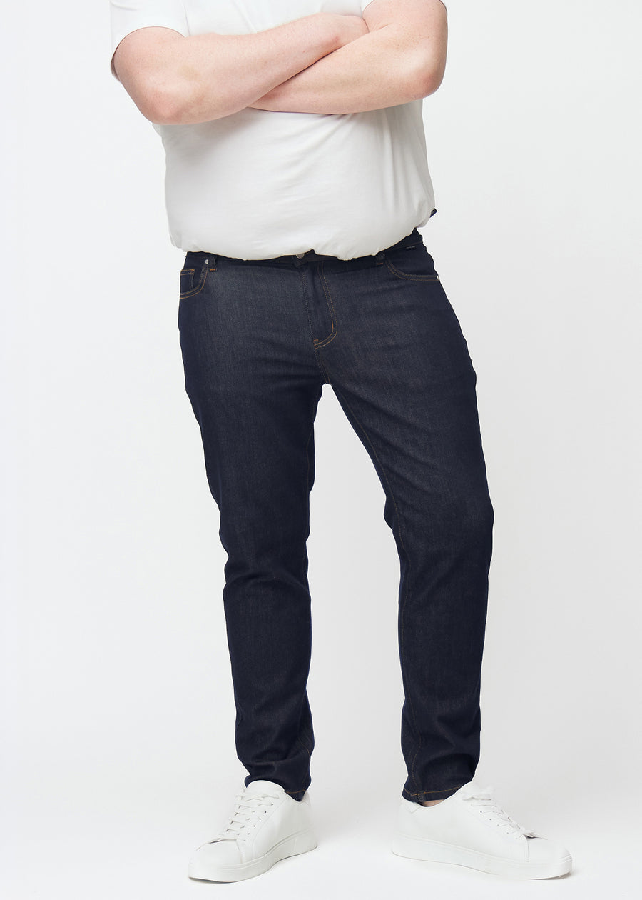 Djupt mörkblå denim jeans för män i färgen Midnights med slim passform sedd framifrån på plus-size-modell.