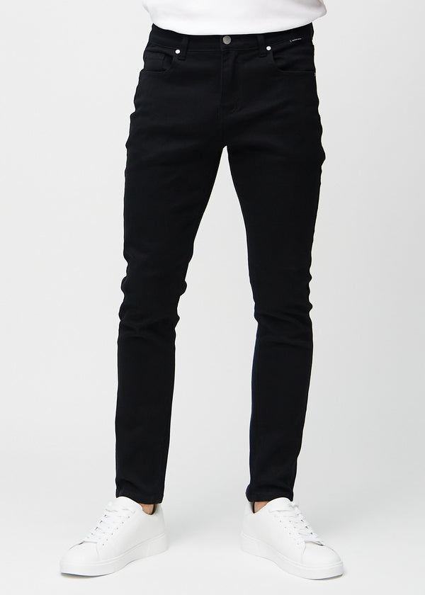 Svarta jeans i slim fit, modellnamn Ravens, som sitter tätt längs benen, sedda framifrån.