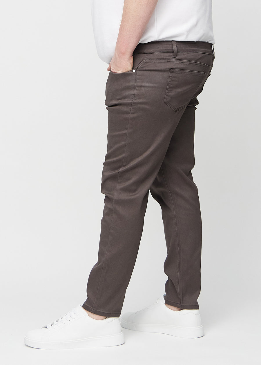 Gråbruna jeans i slim fit sedda från sidan på en plus size-modell.