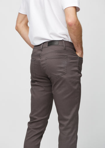 Närbild bakifrån av gråbruna jeans i slim fit som visar detaljer.
