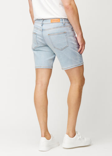 Lyseblå denim shorts til mænd i farven Waves set bagfra, så længden til lige over knæet og pasformen kan ses.