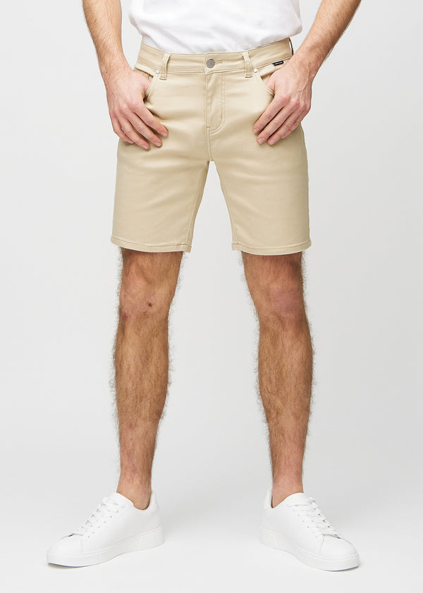 Beige shorts i middle-slim-passform, som följer låren och slutar strax ovanför knät, sedda framifrån.