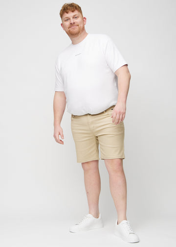Fuldt billede af en plus-size model i beige middle-slim shorts.