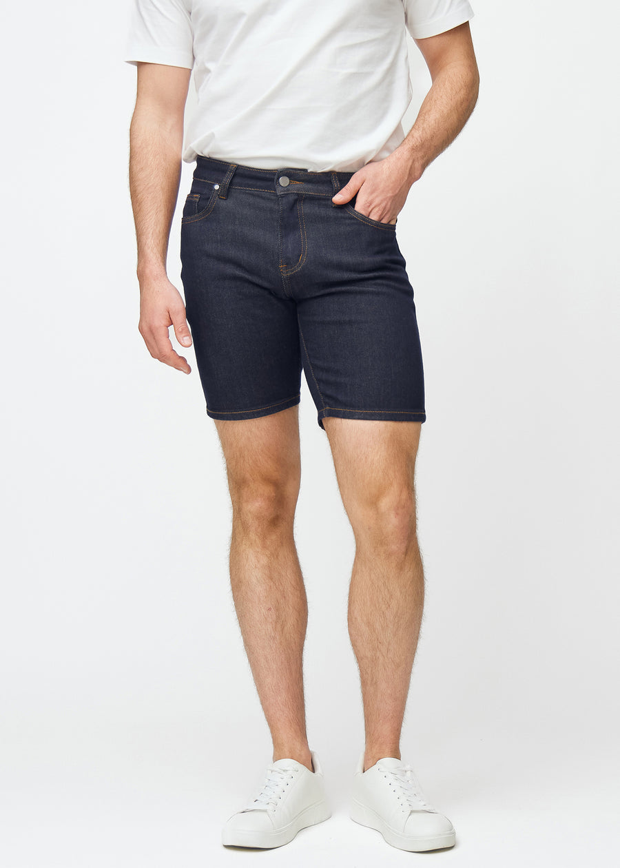 Mörkblå denimshorts för herr i färgen Midnights med slim passform som sitter naturligt vid höften och följer låren tätare än regular, sett framifrån.