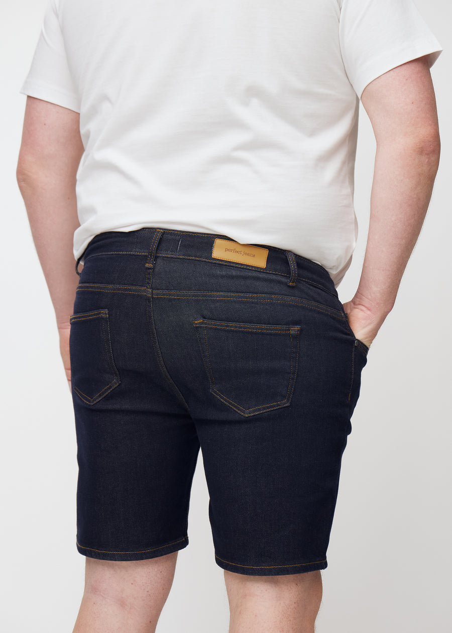 Mörkblå denimshorts för herr i färgen Midnights sett bakifrån i närbild på plus-size modell.