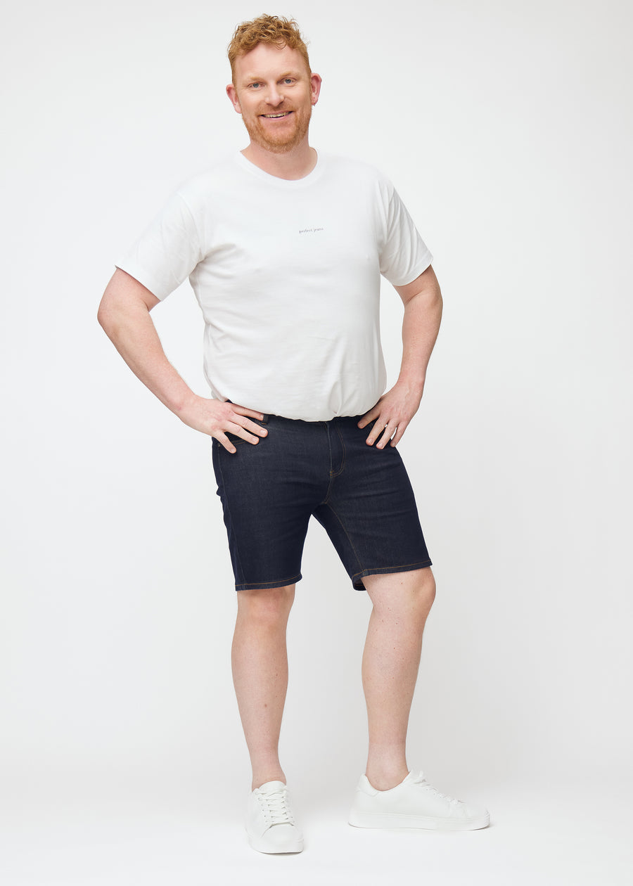 Helbild av plus-size modell i mörkblå denimshorts för herr i färgen Midnights med slim passform.