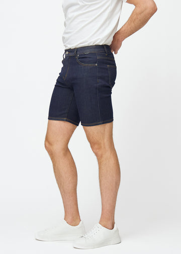 Mörkblå denimshorts för herr i färgen Midnights med slim passform sett från sidan på modell.