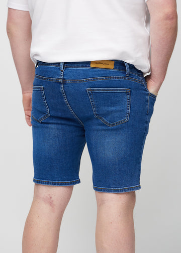 Mörka denim middle-slim shorts sedda bakifrån i närbild på en plus size-modell för att visa detaljer.