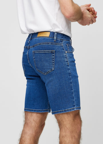 Mörka denim middle-slim shorts sedda bakifrån i närbild för att visa detaljer.