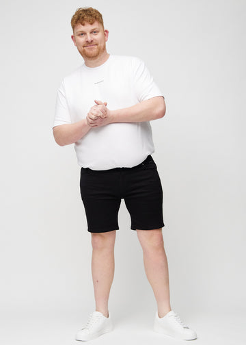 Fuldt billede af en plus-size model i sorte middle-slim shorts.