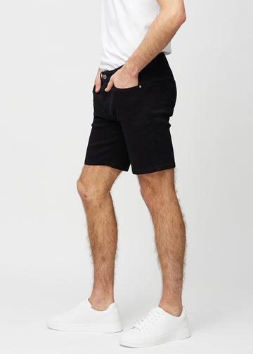 Sorte middle-slim shorts set fra siden på model.