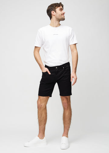 Fuldt billede af model i sorte middle-slim shorts.