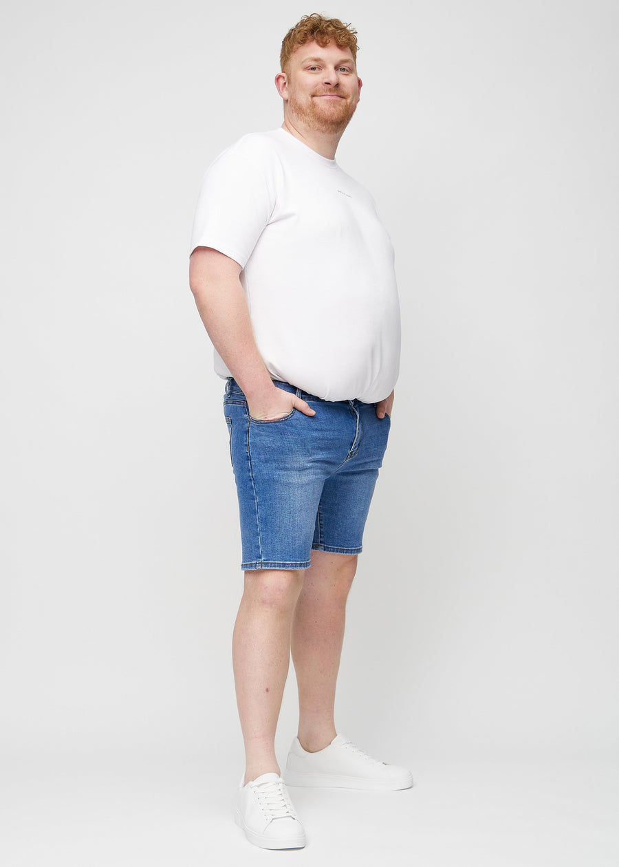 Fuldt billede af en plus-size model i denim middle-slim shorts.