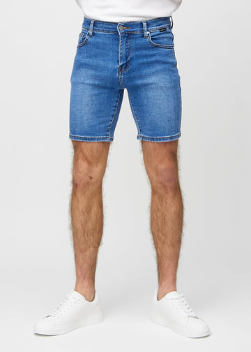 Denim middle-slim shorts, som sidder lige langs låret og slutter lige over knæet, set forfra.