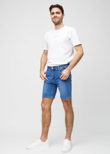 Fuldt billede af model i denim middle-slim shorts.