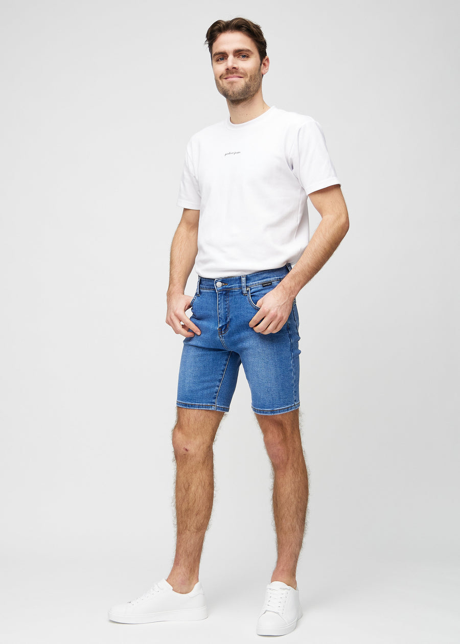 Fuldt billede af model i denim middle-slim shorts.