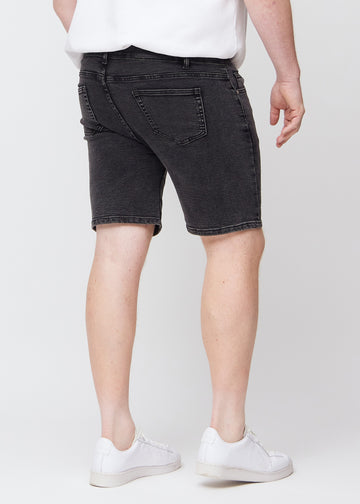 Mørkegrå denim middle-slim shorts set bagfra på en plus-size model, så man kan se hele produktet.