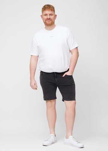Fuldt billede af en plus-size model i mørkegrå denim middle-slim shorts.