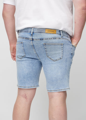 Lys denim middle-slim shorts set bagfra tæt på en plus-size model for at vise detaljer.