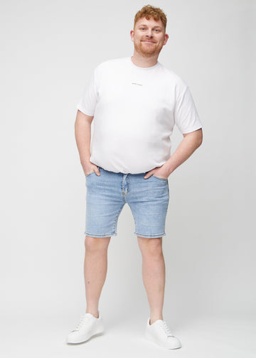 Fuldt billede af en plus-size model i lys denim middle-slim shorts.