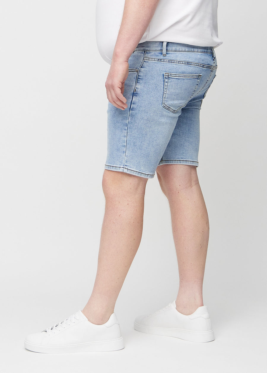 Lys denim middle-slim shorts set fra siden på en plus-size model.