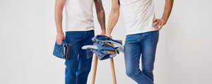 To mænd i blå denim jeans, med en bunke af denim jeans på en skammel