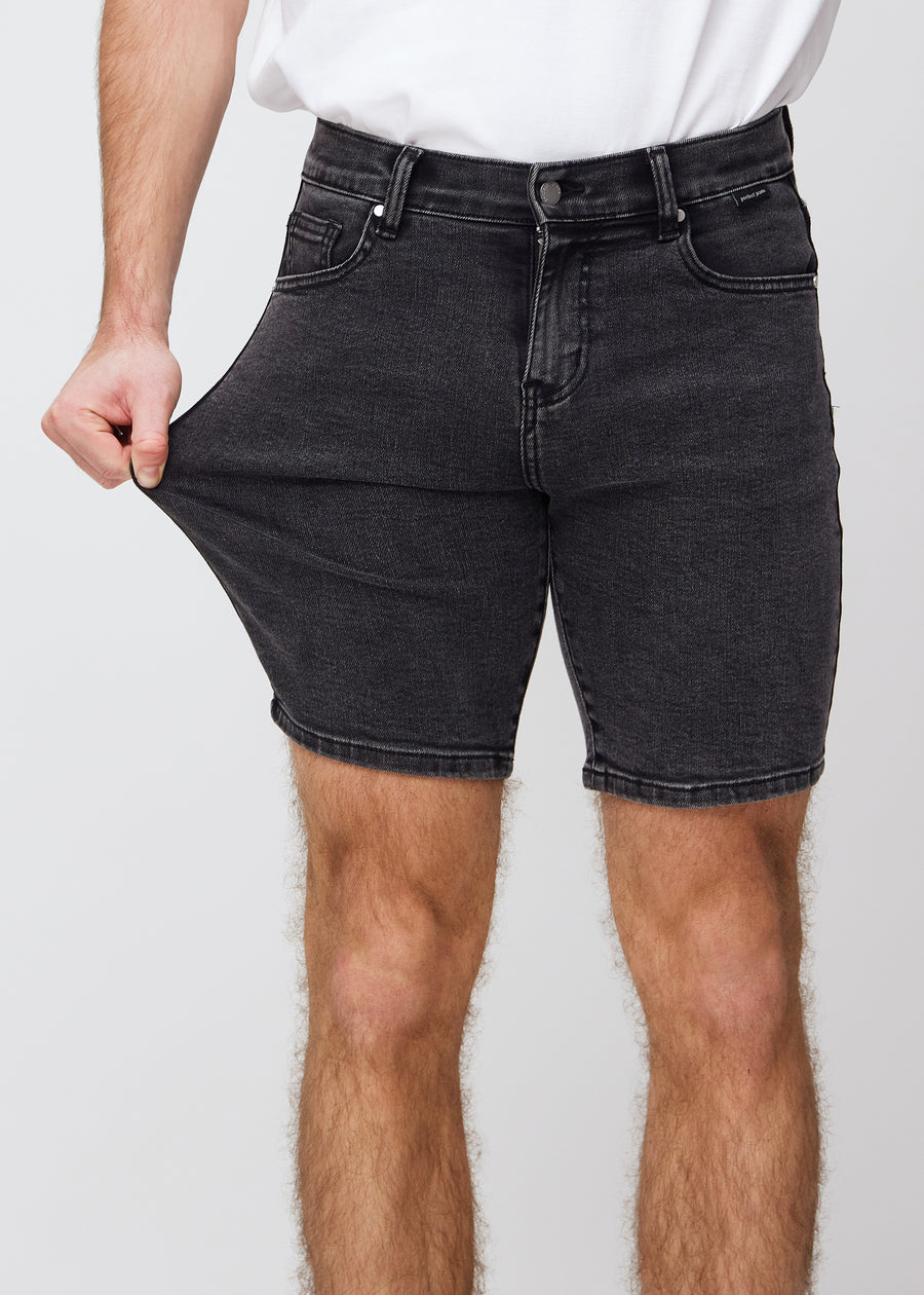 Model strækker shortsene ved låret for at vise stretch.