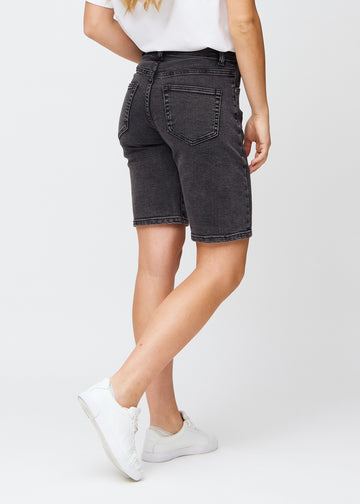 Kvinde i knælange mørkegrå denim shorts, set bagfra