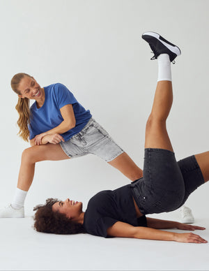 To kvinder i korte lyse- og mørkegrå, stretch shorts fra Perfect Jeans.