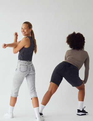 To kvinder i korte lyse- og mørkegrå, stretch shorts og capris fra Perfect Jeans.
