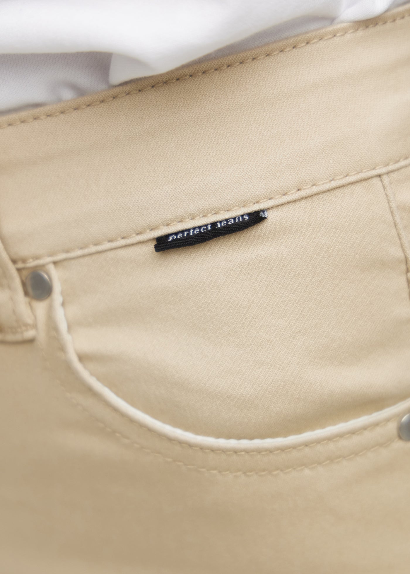 Forlommen på et par beige jeans, hvor man kan se logoet på en plus-size model.