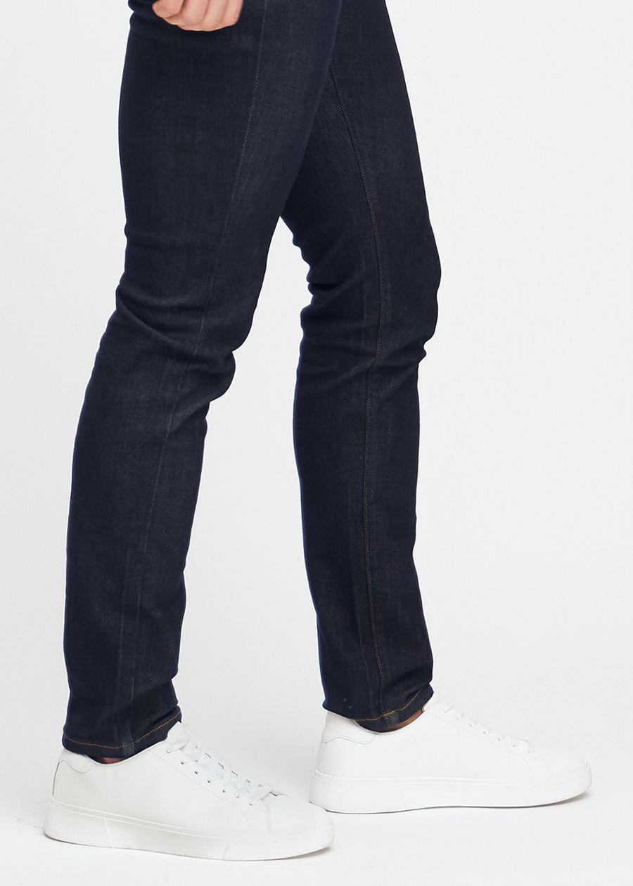 Djupmörkblå denimjeans för män i färgen Midnights med slim passform, visade på nära håll vid anklarna för att framhäva den smala benöppningen.